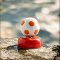 Ceramic Rotating Soccer Ball Figurine – Orange & White Spinning Football Desk Toy on Red Base